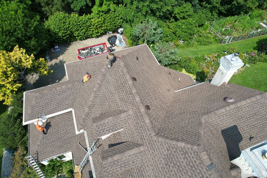 Angled drone view of a finished brown shingle roof with multiple hips and valleys